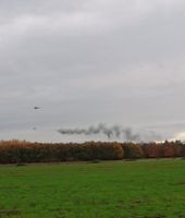 Een helikopter strooit steenmeel boven de Maashorst